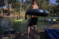 People spend the day at the Jordan River near Kibbutz Kinneret in northern Israel on Saturday, July 30, 2022. (AP Photo/Oded Balilty)