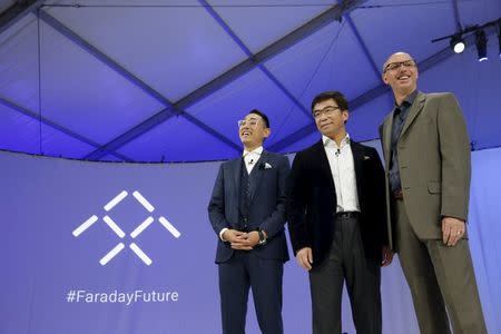 Executives (L-R) Richard Kim, head of global design for Faraday Future, Ding Lei, the co-founder of Leshi's auto division, and Nick Sampson, Faraday Future senior vice president of research and development and product development, pose on stage after the unveiling of the Faraday Future FFZERO1 electric concept car at a news conference in Las Vegas, Nevada January 4, 2016. REUTERS/Steve Marcus