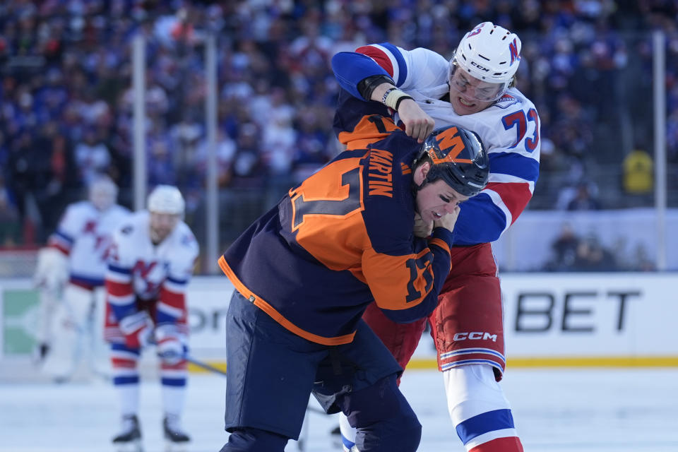 New York Rangers' Matt Rempe, top, fights with New York Islanders' Matt Martin during the first period of an NHL Stadium Series hockey game in East Rutherford, N.J., Sunday, Feb. 18, 2024. (AP Photo/Seth Wenig)