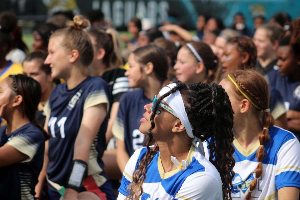 Flag football players from a dozen schools line up on the TIAA Bank Field playing surface as Jaguars general manager Trent Baalke speaks during the Jaguars Prep Girls Flag Football Preseason Classic.