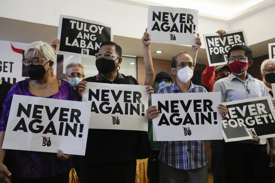 Activists Joel Lamangan, second from left, and Edre Olalia, second from right, hold slogans during a press conference in Quezon city, Philippines, Thursday, July 21, 2022. Activists and human rights victims launched a new campaign in the Philippines Thursday to memorialize and prevent a repeat of the abuses and plunder that marked the martial-law era 50 years ago under the dictator-father of new President Ferdinand Marcos Jr. (AP Photo/Aaron Favila)