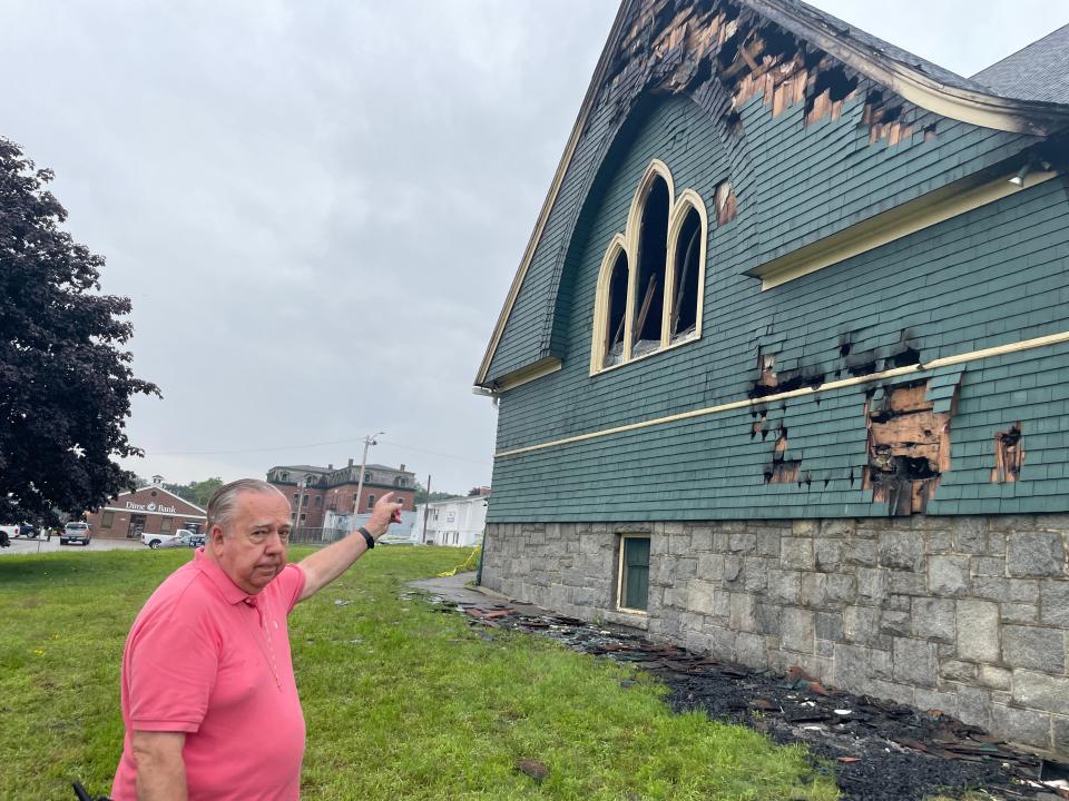 Rev. Jack Shackles, who was pastor of Taftville Congregational Church before his retirement last year, points to where his favorite stained glass window was, showing flowers, before it was destroyed in a Saturday fire.