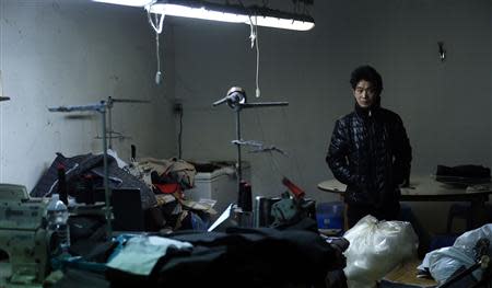 A Chinese immigrant looks on as police officers conduct a check at a textile factory in Prato December 9, 2013. REUTERS/Stefano Rellandini