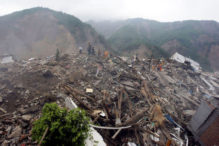 Rescue workers and local residents look for survivors in the ruins of the destroyed old city district, near a mountain at the earthquake-hit Beichuan county, Sichuan province, China, May 15, 2008. REUTERS/Jason Lee/File Photo