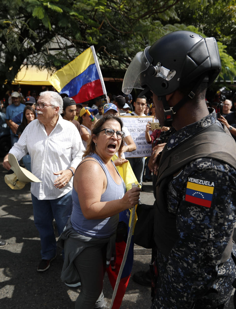 A woman confronts Venezuelan police blocking a crowd of people gathering to march against the government of President Nicolas Maduro, in Caracas, Venezuela, Saturday, March 9, 2019. Security forces are deploying in large numbers in Caracas ahead of the planned demonstrations by supporters of opposition leader Juan Guaido. (AP Photo/Eduardo Verdugo)