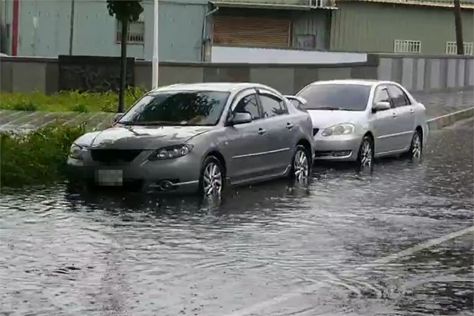 高雄市同盟路和民族路口積水，車輛經過水花四濺。（圖／民視新聞）