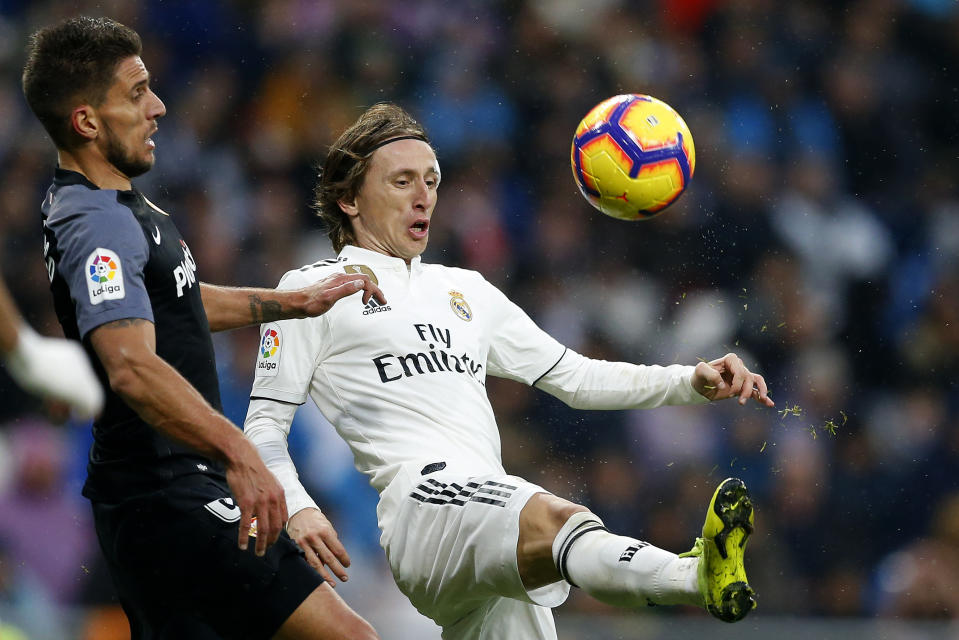 Real Madrid's Luka Modric, right, fights for the ball with Sevilla's Daniel Carrico during a La Liga soccer match between Real Madrid and Sevilla at the Bernabeu stadium in Madrid, Spain, Saturday, Jan. 19, 2019. (AP Photo/Andrea Comas)