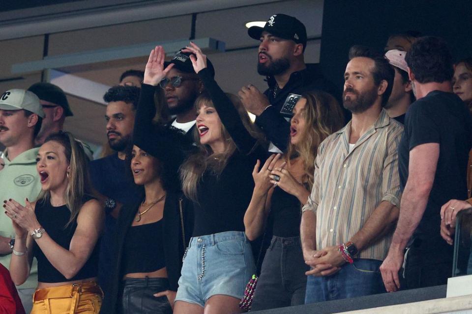 Singer Taylor Swift, left, actress Blake Lively and actor Ryan Reynolds watch Sunday night's action.