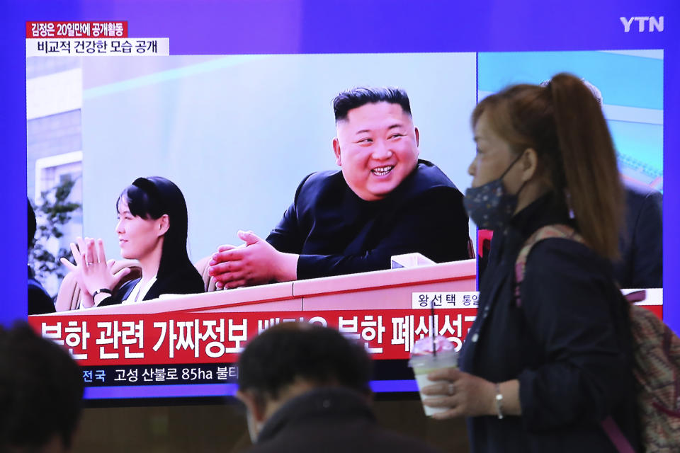 A woman passes by a TV screen showing an image of North Korean leader Kim Jong Un and his sister Kim Yo Jong during a news program at the Seoul Railway Station in Seoul, South Korea, Saturday, May 2, 2020. Kim made his first public appearance in 20 days as he celebrated the completion of a fertilizer factory near Pyongyang, state media said Saturday, ending an absence that had triggered global rumors that he was seriously ill. (AP Photo/Ahn Young-joon)