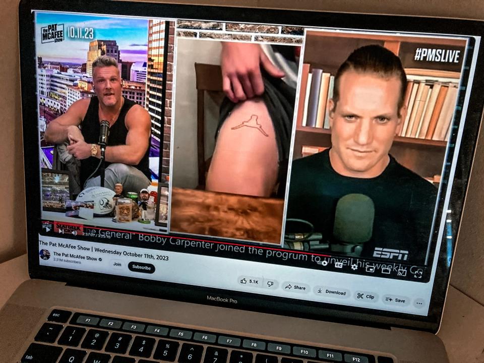 In this screenshot, OU linebacker Danny Stutsman shows Pat McAfee and A.J. Hawk what is apparently a "horns down" tattoo on his thigh during an interview on "The Pat McAfee Show."