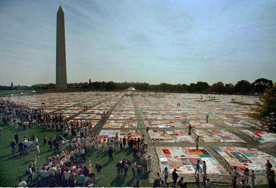 In this Saturday, Oct. 10, 1992 file picture, volunteers and others walk on the 21,000 panel Names Project AIDS Memorial Quilt in Washington.