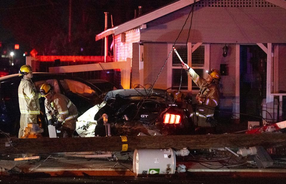 Emergency personnel work Saturday, May 27, 2023 at Murray Avenue and Johnson Street after a collision between two cars into a house and power pole left many residents and businesses in the area without power.