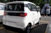 FILE PHOTO: Man walks past a Wuling Hong Guang MINI EV at a SAIC-GM-Wuling dealership in Beijing