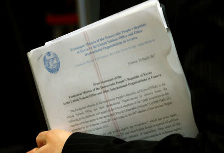 Mun Jong Chol, counselor at the North Korea mission to the U.N. in Geneva, holds copies of a press release aside of a meeting of the Human Rights Council at the United Nations in Geneva, Switzerland March 24, 2017. REUTERS/Denis Balibouse