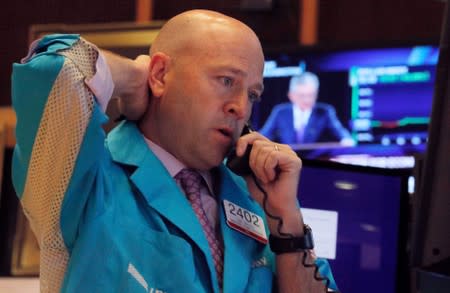 A trader works as a screen shows Federal Reserve Chairman Jerome Powell's news conference after the U.S. Federal Reserve interest rates announcement on the floor of the New York Stock Exchange (NYSE) in New York