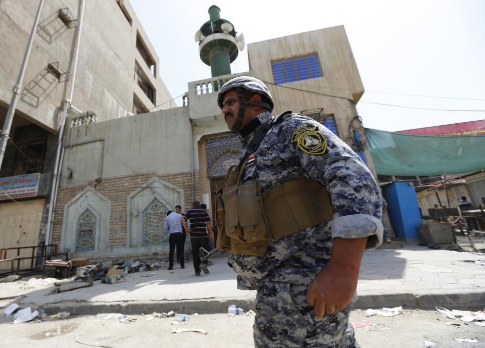 A member of the Iraqi security forces stands guard outside a Shi'ite mosque after a bomb attack in Baghdad May 27, 2014. (REUTERS/Thaier Al-Sudani)