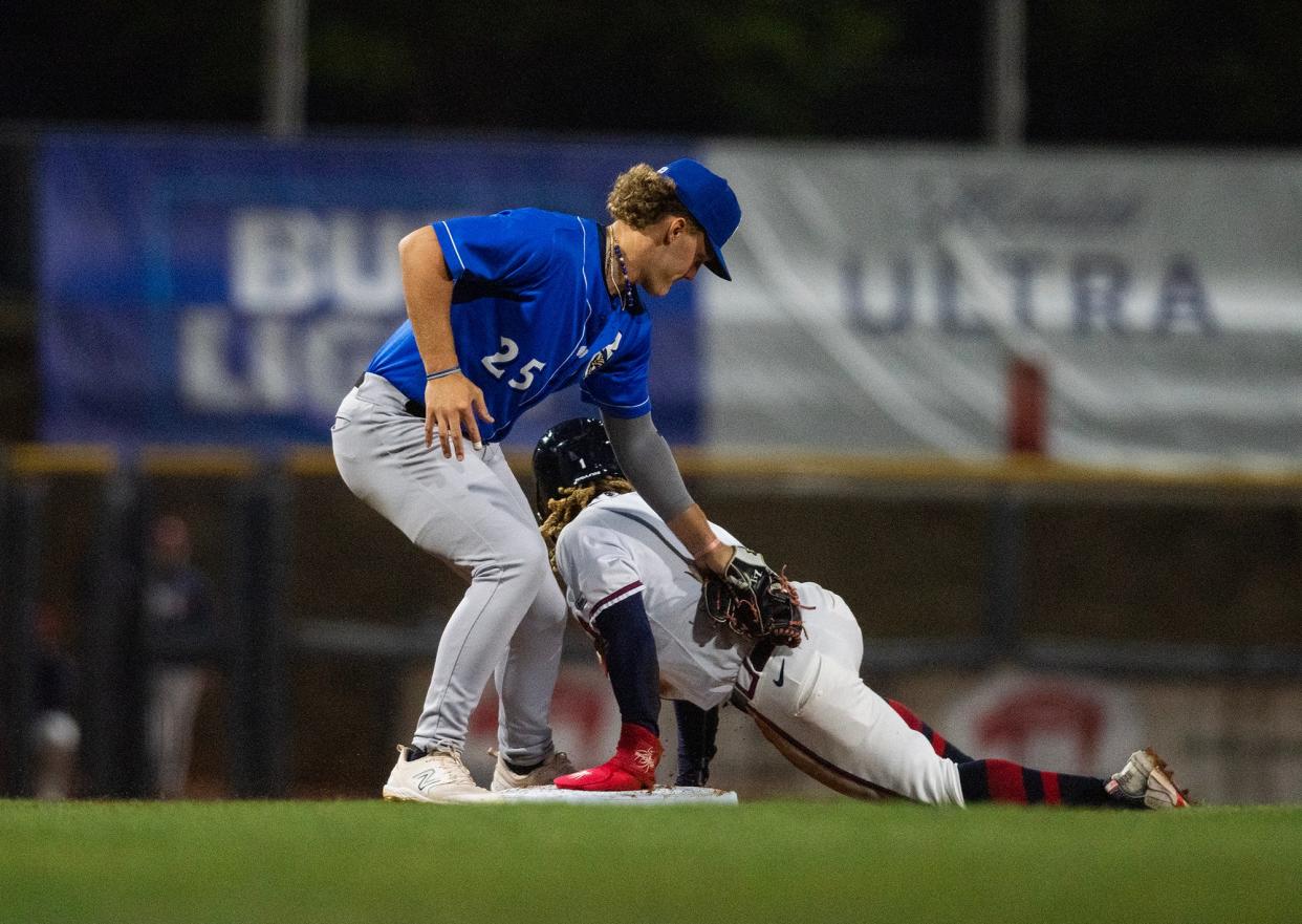 Biloxi Shuckers' Brock Wilken attempts to tag out Mississippi Braves' Justin Dean during the Class AA opening day game April 9.