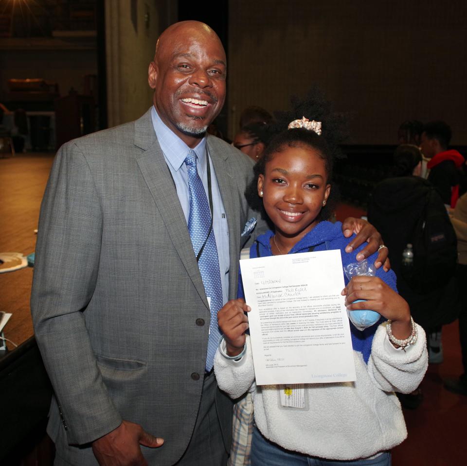 Brockton High School Principal Kevin McCaskill stands with Brockton High School senior Midelange Charlot after she received her academic scholarship from Livingstone College on Wednesday, April 3, 2024.