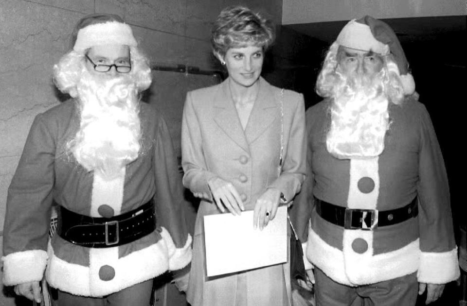 <p>Princess Diana attends a lunch with author and politician, Lord Jeffrey Archer and former Chancellor of the Exchequer, Lord Denis Healey—both dressed as Santa Claus.</p>
