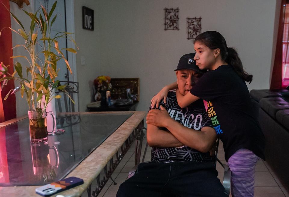 Manuel De La Cruz, South Bay, receives a hug from his 17-year-old daughter, Anahi, after an emotional moment inside their home on Tuesday, November 1, 2022, in South Bay, FL. Manuel is the sole provider for his family, which includes a special needs child in Anahi, who has Down's syndrome. After losing two fingers during an accident while working, Manuel has had trouble finding steady work.