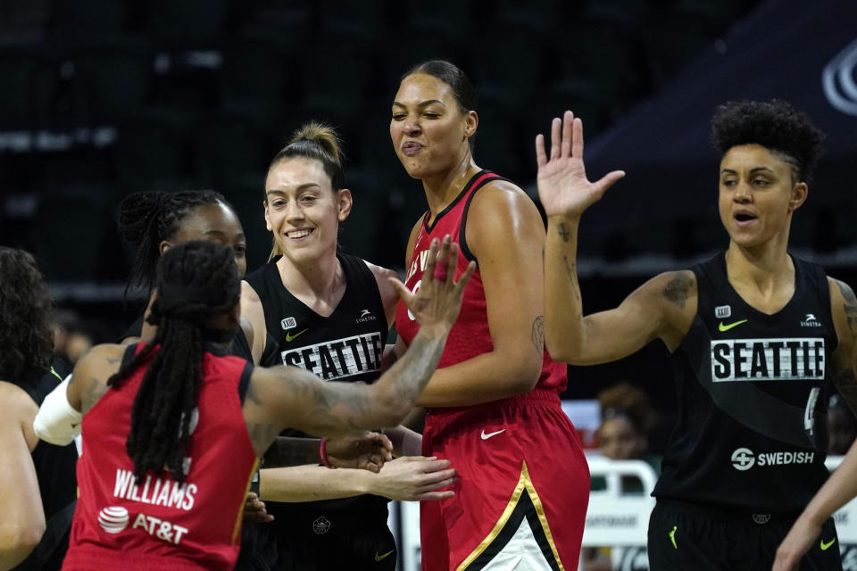 Seattle Storm's Breanna Stewart, second left, and Candice Dupree (4) greet Las Vegas Aces' Riquna Williams and Liz Cambage as the team's prepare to tipoff their season in a WNBA basketball game Saturday, May 15, 2021, in Everett, Wash. (AP Photo/Elaine Thompson)