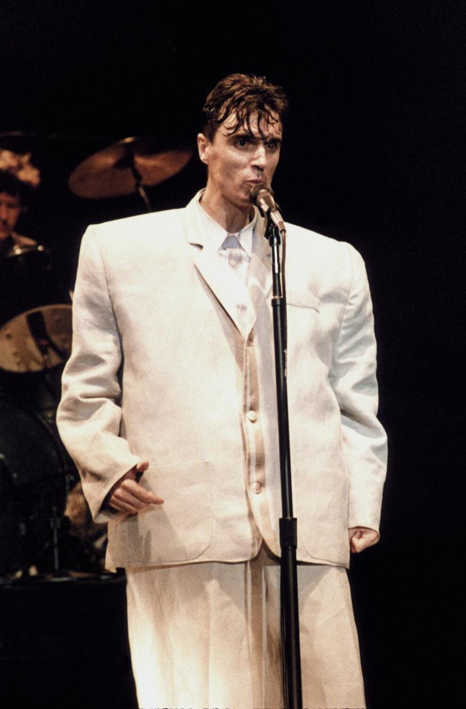 A rock singer in an oversized tan suit