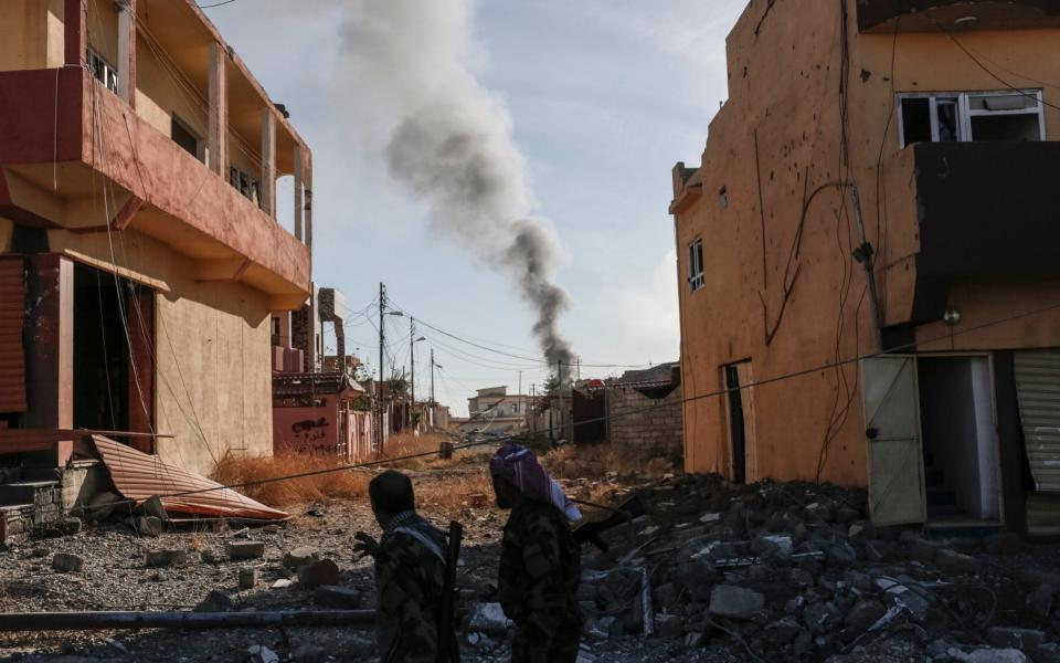 Smoke rises above the Yazidi town of Sinjar, Iraq, shortly after the town was liberated from Isis by the PKK and Iraqi Kurdish forces in 2015 - Sam Tarling 