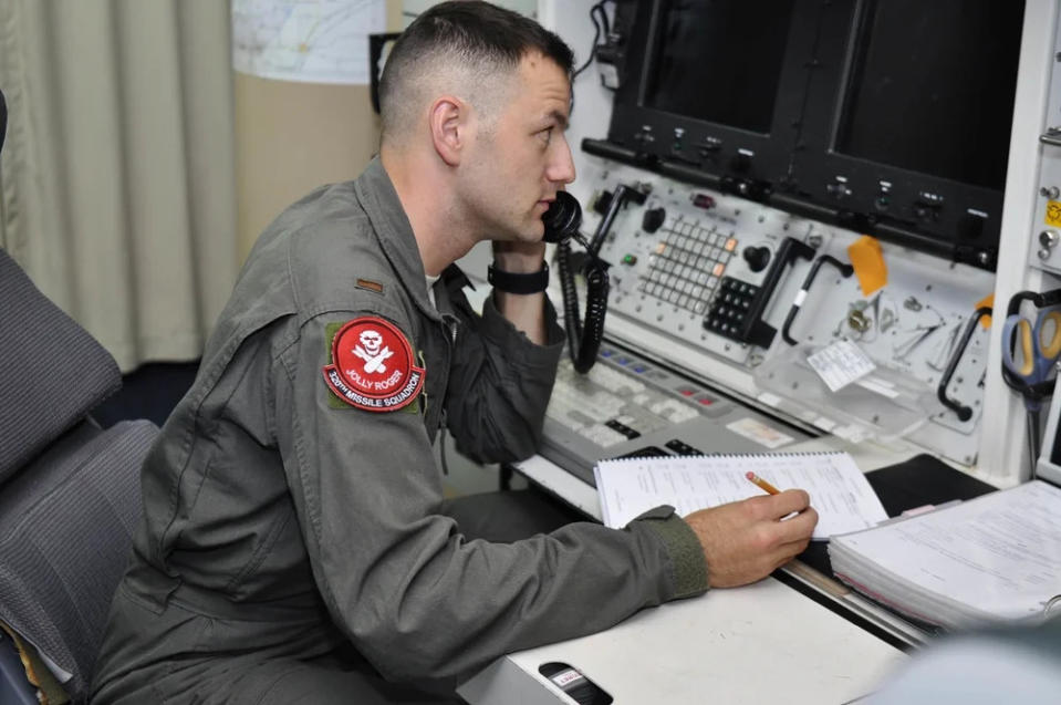 Second Lieutenant Adam Pauley, 320th Missile Squadron deputy combat crew commander, communicates over the phone during a Simulated Electronic Launch-Minuteman test inside a launch control center at a missile alert facility in the 90th Missile Wing missile complex, Aug. 21, 2018. Accomplishing the SELM validates these claims and increases the deterrent capability of the Minuteman III ICBM weapon system. (U.S. Air Force photo by Senior Airman Breanna Carter) 