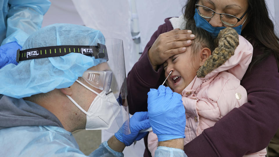 FILE - In this Nov. 10, 2020, file photo, Kim Tapia holds her granddaughter Amariah Lucero, 3, as she's tested at the Utah National Guard's mobile testing site for COVID-19 in Salt Lake City. The U.S. has recorded about 10.3 million confirmed infections, with new cases soaring to all-time highs of well over 120,000 per day over the past week. (AP Photo/Rick Bowmer, File)