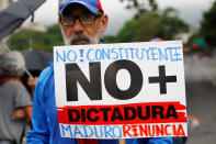 <p>An opposition supporter holds a placard that reads “No to the constituent assembly. No more dictatorship. Maduro, resign” during a protest against Venezuela’s President Nicolas Maduro’s government in Caracas, Venezuela May 2, 2017. (Photo: Carlos Garcia Rawlins/Reuters) </p>