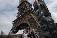 Visitors take a selfie at the main entrance during the opening up of the top floor of the Eiffel Tower, Wednesday, July 15, 2020 in Paris. The top floor of Paris' Eiffel Tower reopened today as the 19th century iron monument re-opened its first two floors on June 26 following its longest closure since World War II. (AP Photo/Francois Mori)