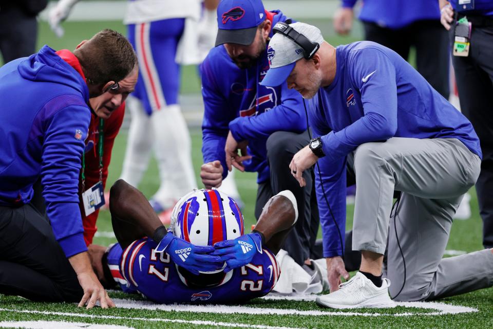 An injured Buffalo Bills cornerback Tre'Davious White (27) is helped by head coach Sean McDermott, right, and medical staff.