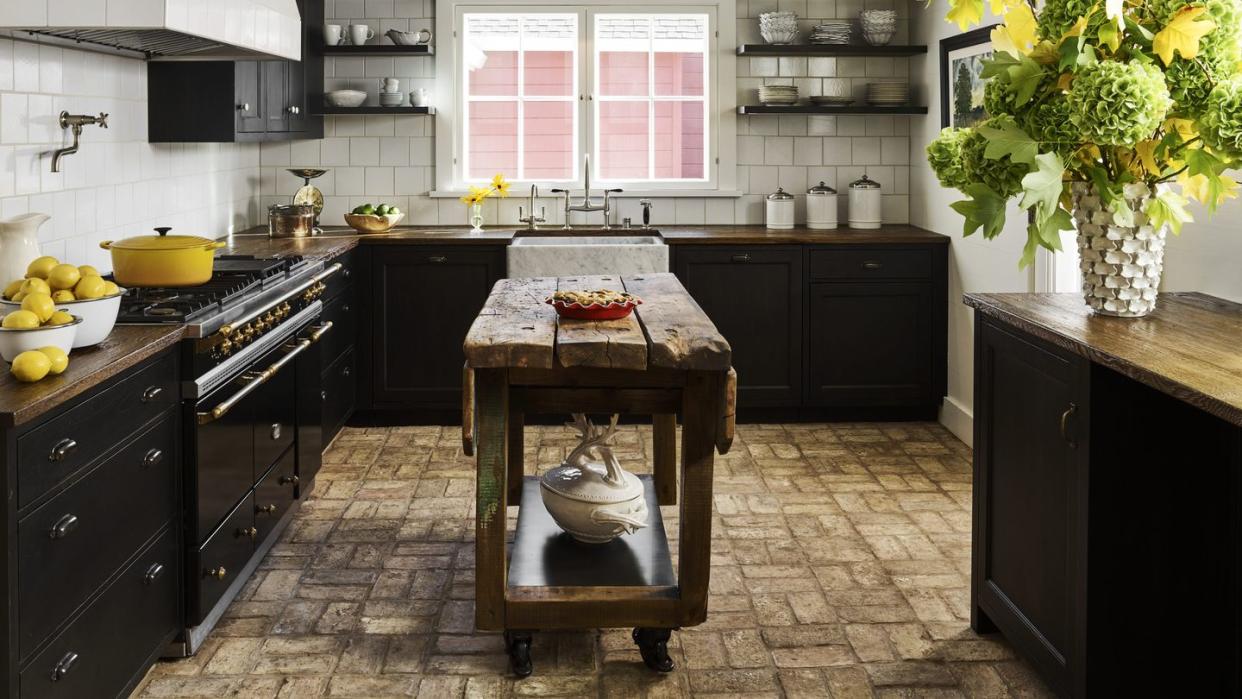 ceiling height wall tiles in alternating dimensions and reclaimed brick flooring and oak countertops anchor the kitchen in beautiful rusticity