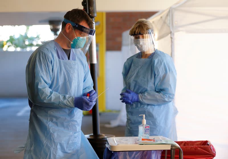 FILE PHOTO: Nurse Jeff Gates processes a patient sample at a drive-through testing clinic for coronavirus, flu and RSV, currently by appointment for employees at UW Medical Center Northwest