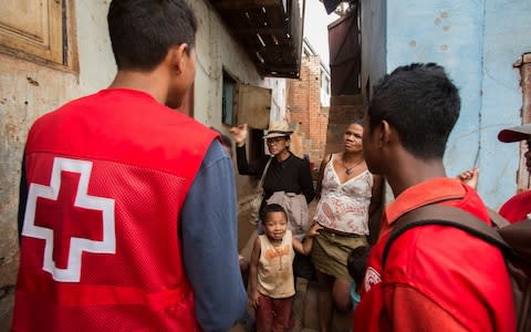Red Cross volunteers talk to villagers about the plague outbreak, 30 miles west of Antananarivo, Madagascar, Monday, Oct. 16, 2017 - Credit: AP