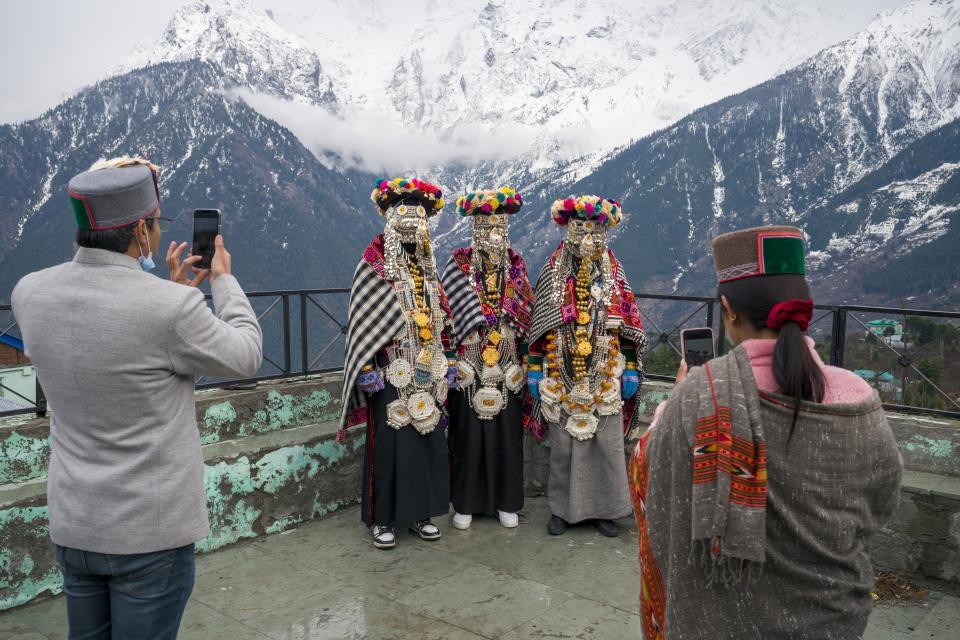 Men in traditional costume pose for photographs at a Hindu shrine in Kalpa village of the Kinnaur district in the Himalayan state of Himachal Pradesh, India, Monday, March 13, 2023. (AP Photo/Ashwini Bhatia)