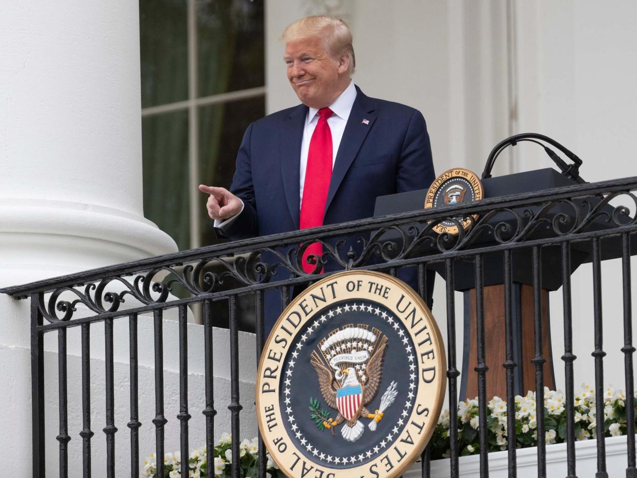 President Donald Trump points during a Rolling to Remember Ceremony to honour the nation's veterans and POW/MIA from the Blue Room Balcony of the White House on Friday 22 May 2020: Alex Brandon/AP