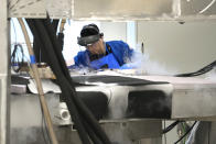 A magnet test engineer checks fluid levels in a testing device at Commonwealth Fusion Systems, in Devens, Mass., Wednesday, Oct. 11, 2023. Commonwealth is trying to create fusion inside what's called a tokamak. Nuclear fusion, which would be a new source of carbon-free energy, melds two hydrogen atoms together to produce a helium atom and a lot of energy. (AP Photo/Steven Senne)