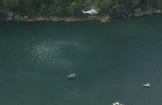 A search and rescue helicopter flies above the scene of the crash  (Australian Media Pool via AP)