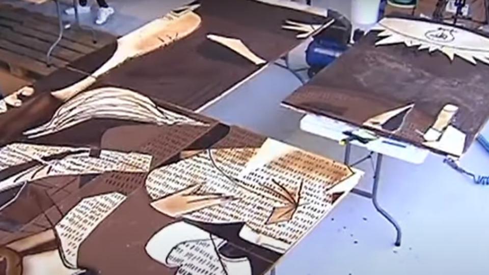 an overhead shot of two tables with large slabs of chocolate with Picasso's Guernica painted on them