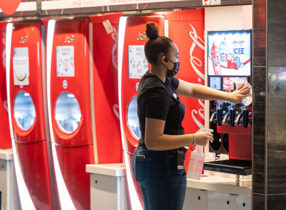 NEW YORK, NEW YORK - MARCH 05: A worker cleans a and Icee 
 and Coca-Cola soda machines at AMC Lincoln Square 13 on March 05, 2021 in New York City. AMC Theatres reopened its New York area locations today, with new safety precautions in place, for the first time since closing in March 2020 because of the coronavirus (COVID-19) pandemic. (Photo by Noam Galai/WireImage)