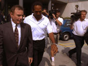 <p>Former NFL star O.J. Simpson, center, and his attorney Howard Weitzman, right, are besieged by the media as they leave police headquarters in downtown Los Angeles Monday, June 13, 1994, after Simpson was questioned in connection with the apparent murders of his ex-wife Nicole Brown Simpson and Ronald Lyle Goldman, 26, at the woman’s Los Angeles condominium. (Photo: Michael Caulfield/AP) </p>