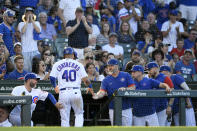 Chicago Cubs' Willson Contreras (40) is greeted by manager David Ross, right, at the dugout after scoring against the Cincinnati Reds during the first inning of a baseball game Wednesday, June 29, 2022, in Chicago. (AP Photo/Paul Beaty)