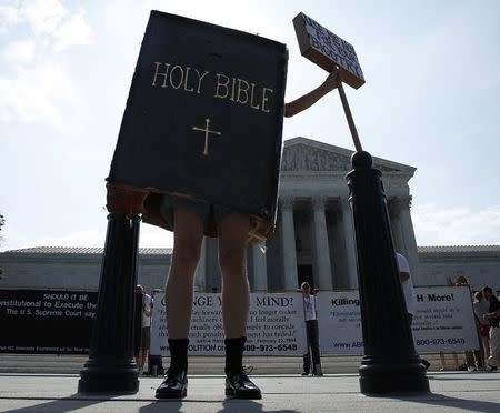 A protester dressed as a copy of the Bible joins groups demonstrating outside the U.S. Supreme Court in Washington June 30, 2014. REUTERS/Jonathan Ernst