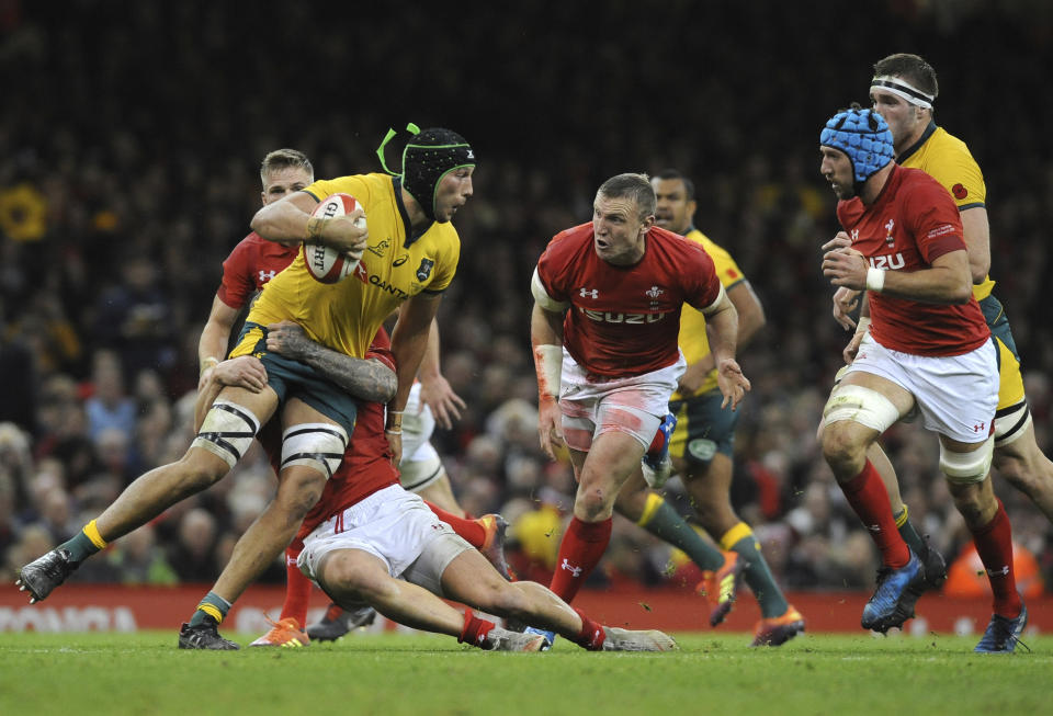 Australia's Adam Coleman looks for support as he is tackled by a Welsh defender during the rugby union international match between Wales and Australia at the Principality Stadium in Cardiff, Wales, Saturday, Nov. 10, 2018. (AP Photo/Rui Vieira)