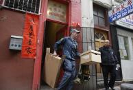 FILE - In this March 26, 2014 file photo, an FBI agent carries out boxes of evidence following a search of a Chinatown fraternal organization in San Francisco. The FBI spent many millions of dollars and used more than a dozen undercover operatives posing as honest businessmen and Mafia figures alike during its seven year organized crime investigation centered in San Francisco’s Chinatown. Now, an increasing number of the defendants caught up in the probe that has ensnared a state senator and an aide are arguing that the FBI and its undercover agents are guilty of entrapment, luring otherwise honest people to go along with criminal schemes hatched by federal officials. (AP Photo/Eric Risberg, File)