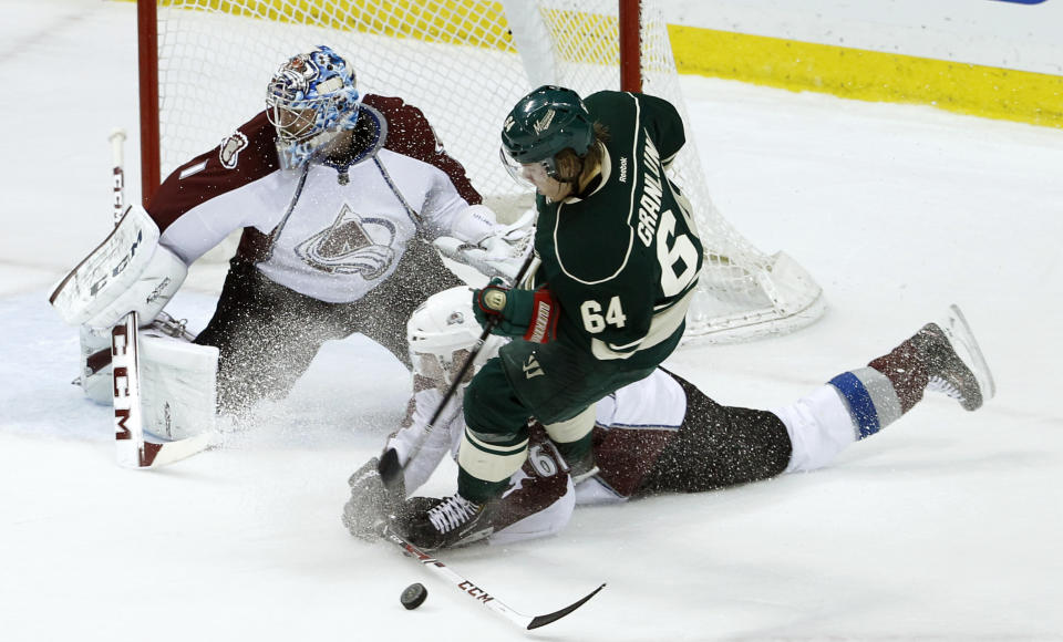 Colorado Avalanche defenseman Andre Benoit and Minnesota Wild center Mikael Granlund (64), of Finland, battle for the puck in front of Avalanche goalie Semyon Varlamov (1), of Russia, during the first period of Game 4 of an NHL hockey first-round playoff series in St. Paul, Minn., Thursday, April 24, 2014. (AP Photo/Ann Heisenfelt)