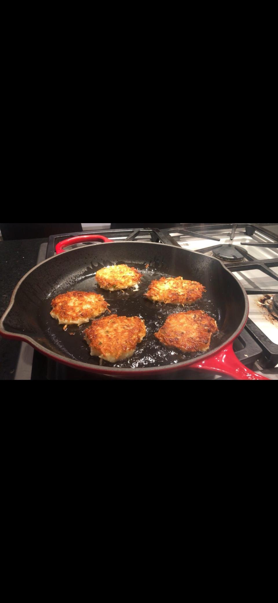 Sharon Madnek's latkes bubble as they fry.