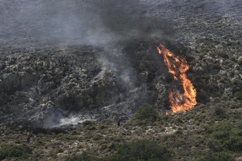 Firefighters approach a wildfire at Elafonisos island, south of Peloponnese peninsula, on Saturday, Aug. 10, 2019. A wildfire which broke out on Elafonisos island in southern Greece on Saturday has prompted the evacuation of a hotel and camping as a precautionary measure, with no injuries reported, according to Greek national news agency AMNA. (AP Photo/Nikolia Apostolou)