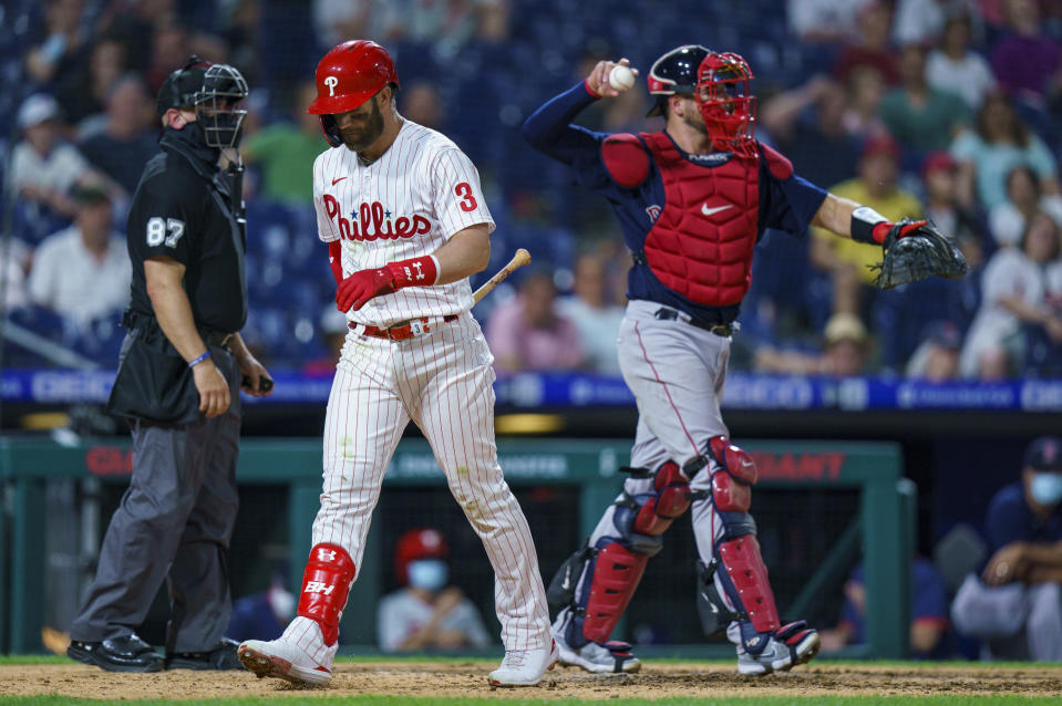 Philadelphia Phillies' Bryce Harper, center, walks back to the dugout after striking out during the seventh inning of the team's baseball game against the Boston Red Sox, Saturday, May 22, 2021, in Philadelphia. The Red Sox won 4-3. (AP Photo/Chris Szagola)